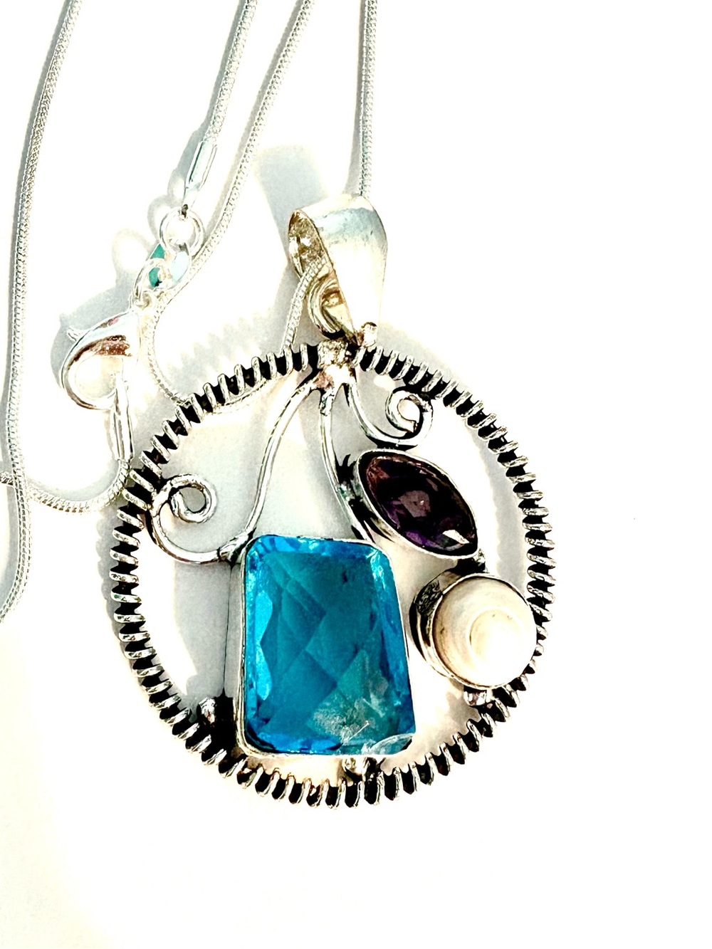 2 inch, 925 marked, Blue Topaz, Amethyst, and Pearl pendant on a silver chain.